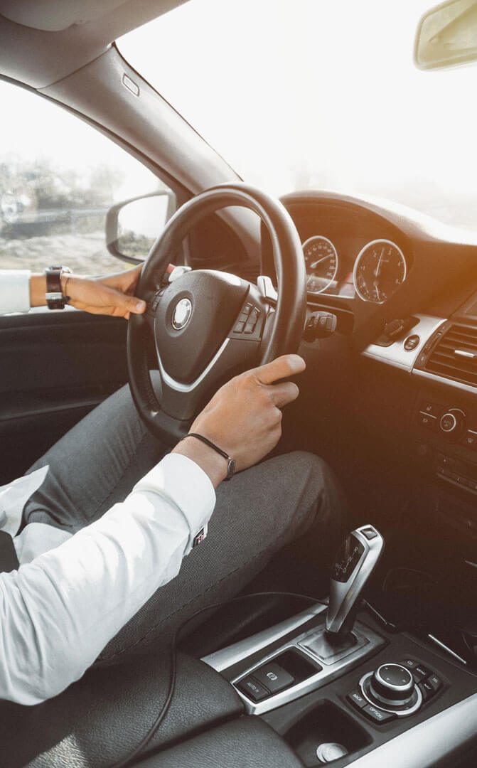 Motorista particular ao volante de uma viatura executiva